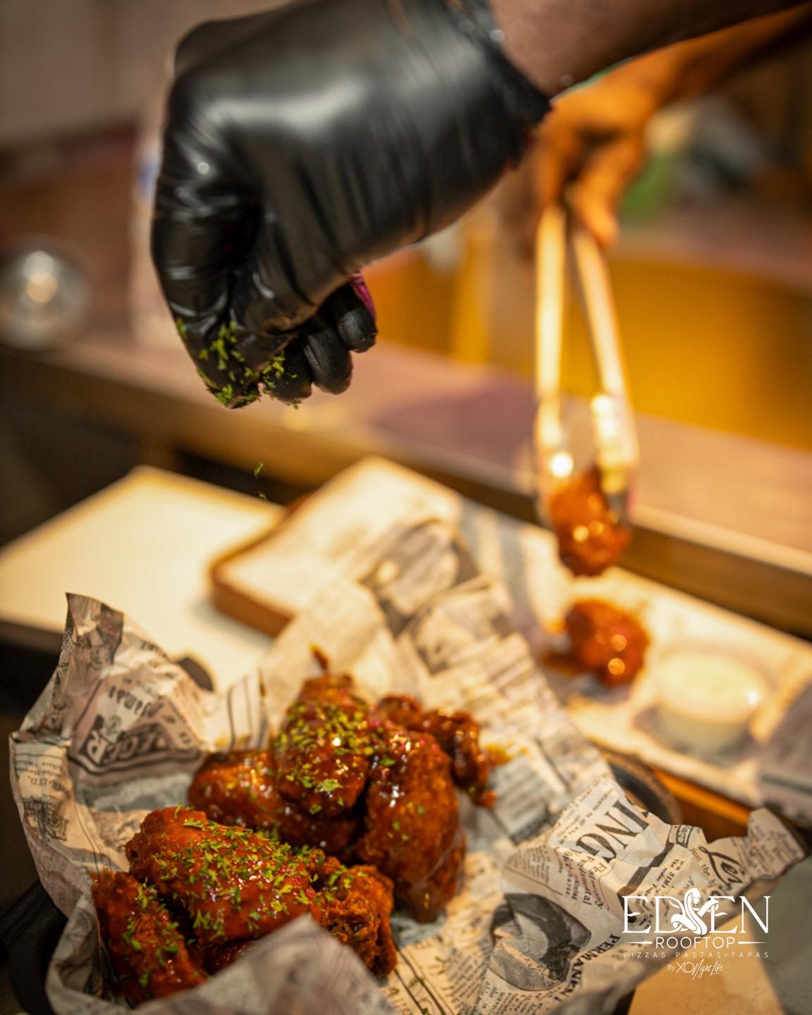 Wings being garnished at Eden Rooftop